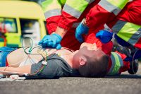 Cardiopulmonary resuscitation. Rescue team (doctor and a paramedic) resuscitating the man on the street.